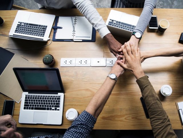 Hands meet over table computers